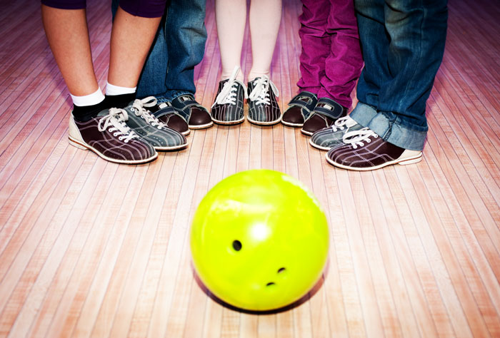Family-friendly sober activities, sober activities, fun sober, view of family's feet standing around bowling ball